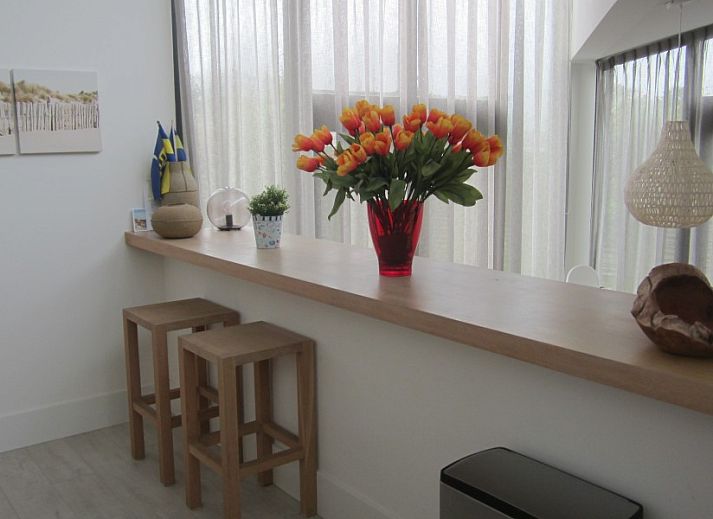 Buiten eetgedeelte van Duyngolf 71 vakantiehuis in Hollum Ameland met ruime tafel en stoelen.