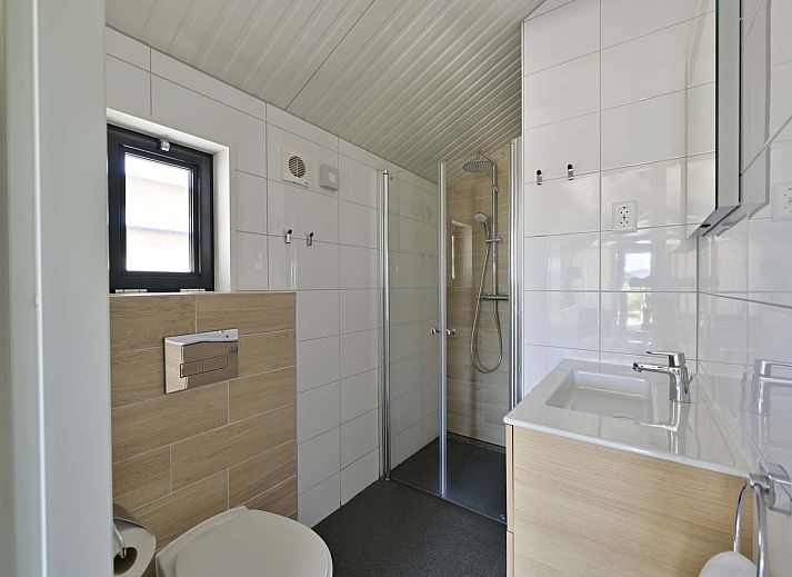 Vorderseite eines freistehenden Hauses in Hollum, Ameland, mit bequemen Sitzgelegenheiten und Blick auf die Waddeninseln.