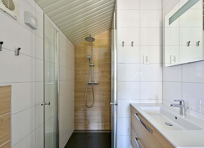 Vorderseite eines freistehenden Hauses in Hollum, Ameland, mit bequemen Sitzgelegenheiten und Blick auf die Waddeninseln.