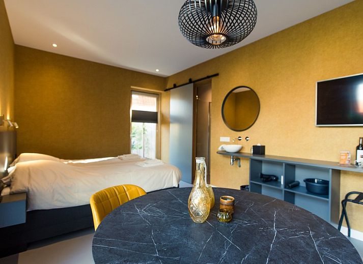 Komfortables Schlafzimmer in der Wohnung Breeze 1, Hollum, Ameland mit moderner Einrichtung und Blick auf die Natur.