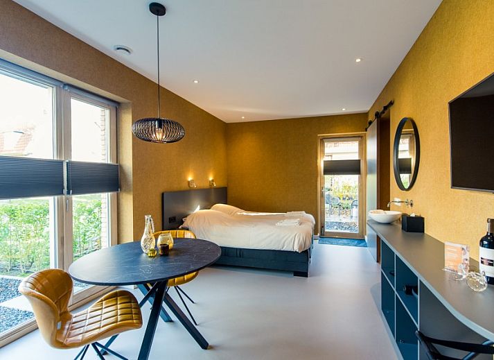 Komfortables Schlafzimmer in der Wohnung Breeze 1, Hollum, Ameland mit moderner Einrichtung und Blick auf die Natur.