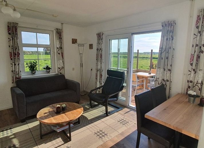 Cozy living room of Ilsebil vacation home in Hollum, Ameland with comfortable seating.
