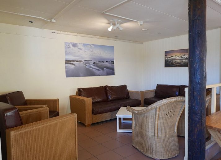 Terrace at The Achterschuur vacation home in Hollum, Ameland with seating for relaxation.