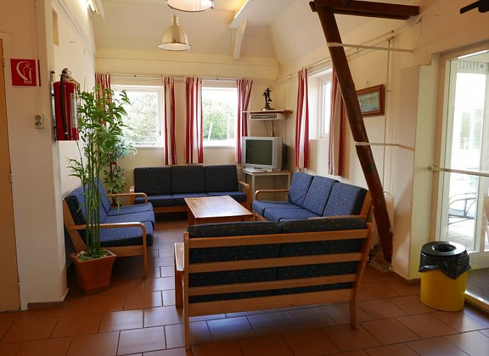 Terrace at The Achterschuur vacation home in Hollum, Ameland with seating for relaxation.