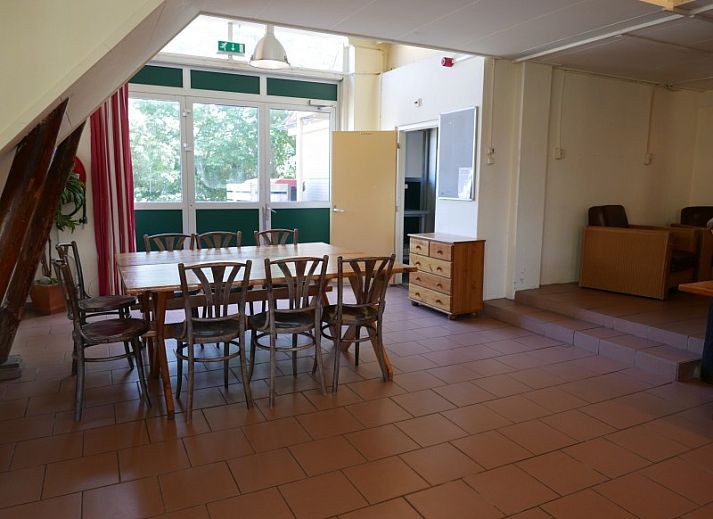 Terrace at The Achterschuur vacation home in Hollum, Ameland with seating for relaxation.