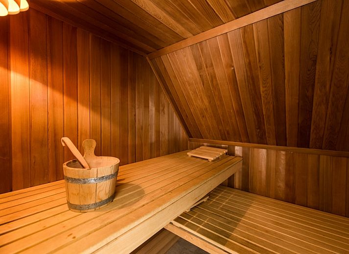 Gezellige woonkamer in Engelsmanduinvilla 6, een vakantiehuis in Hollum, Ameland, met comfortabele banken en veel natuurlijk licht.