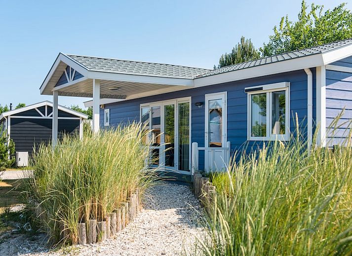 Duinchalet 4 in Hollum, Ameland biedt een charmant vakantiehuis met veranda, omgeven door groene natuur op de Waddeneilanden.