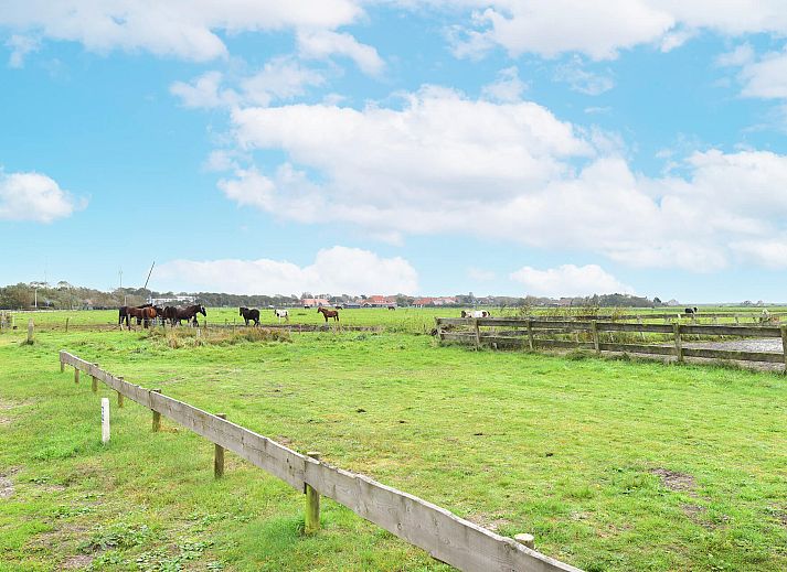 Lichte woonkamer in Vrijstaande woning in Hollum, Ameland met uitzicht op de omgeving.