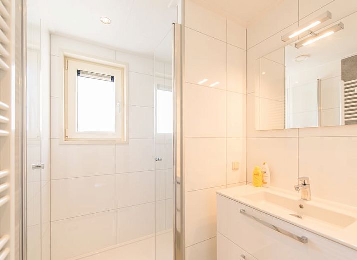 Gezellige woonkamer van Waddenlodge 6 in Hollum, Ameland met ruime zitbank, grote ramen en veel natuurlijk licht.