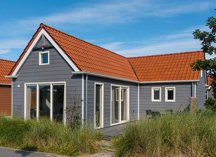 Gezellige woonkamer van Waddenlodge 6 in Hollum, Ameland met ruime zitbank, grote ramen en veel natuurlijk licht.