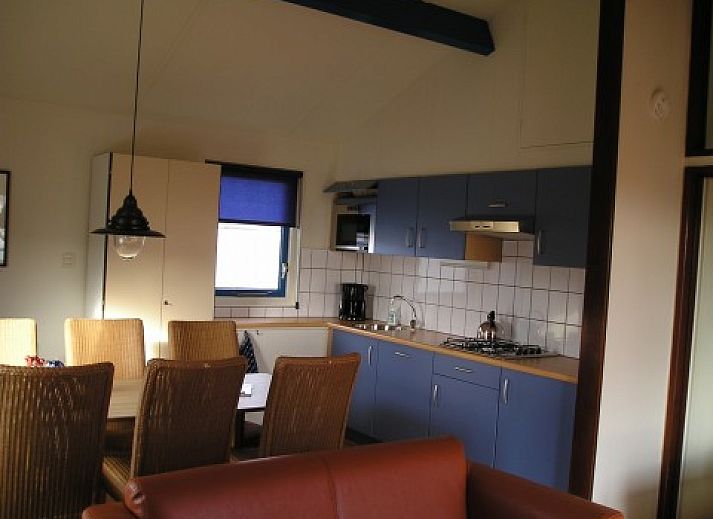 Kleefkruid Bungalow in Hollum, Ameland, umgeben von grner Natur und blauem Himmel.