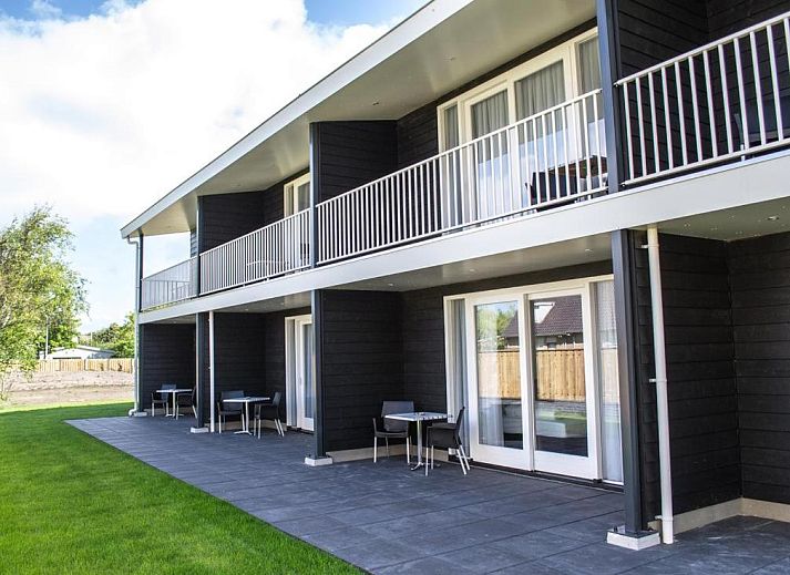 Moderne woonkamer in De Berkenhof appartement, Nes, Ameland. Comfortabele zithoek met veel natuurlijk licht.