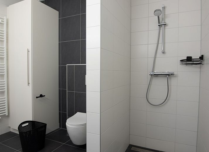 Eettafel in Nesserduinen 42A vakantiehuis in Nes, Ameland met servies en uitzicht op de groene omgeving.