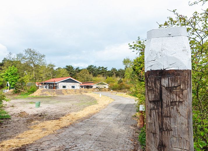 Eettafel in Nesserduinen 42A vakantiehuis in Nes, Ameland met servies en uitzicht op de groene omgeving.