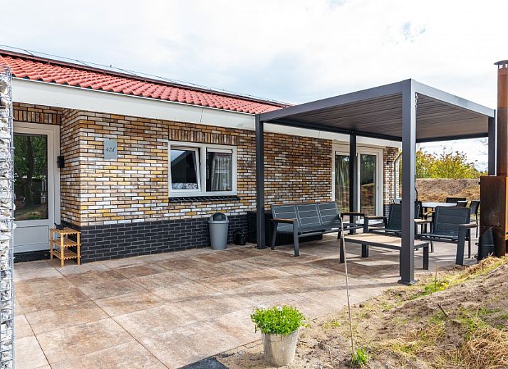 Veranda of vacation home Nesserduinen 42D in Nes, Ameland with modern seating area and canopy.