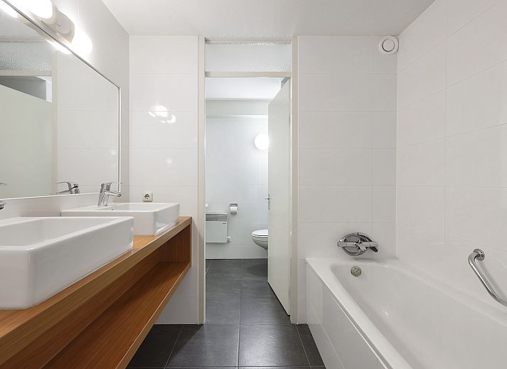 Balkon van Ameland State 2-persoons appartement in Nes, Ameland, met uitzicht op de groene omgeving.