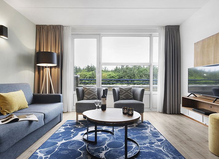 Cozy sitting area in Ameland State apartment in Nes, Ameland, overlooking green surroundings.