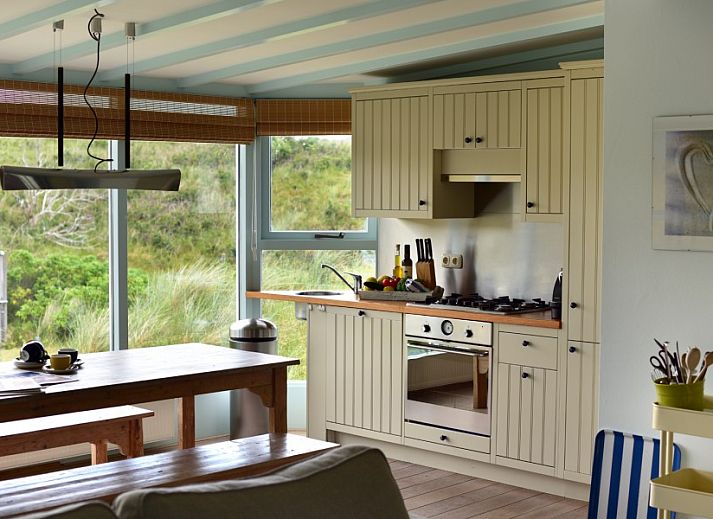 Salt bungalow in Buren, Ameland with charming thatched roof and surrounded by lush dunes.