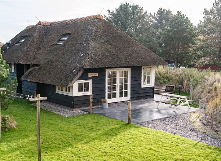 Vakantiehuis Tureluur in Buren, Ameland met rieten dak en groene tuin.