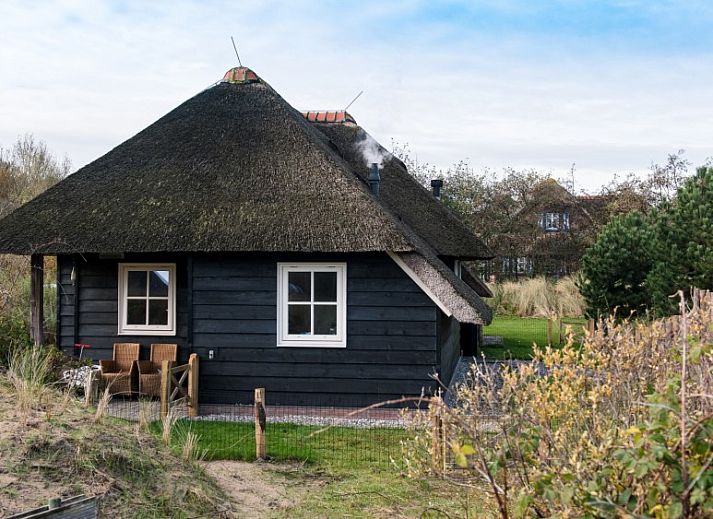 Vakantiehuis Tureluur in Buren, Ameland met rieten dak en groene tuin.