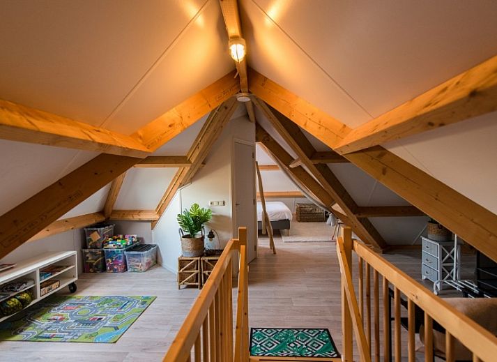 Zijaanzicht van Tureluur vakantiehuis in Buren, Ameland met houten stoelen.