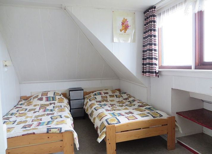 Gemuetliches Wohnzimmer des Ferienhauses Zeerust auf Schiermonnikoog, mit Korbmoebeln und Blick auf die Natur des Wattenmeeres.