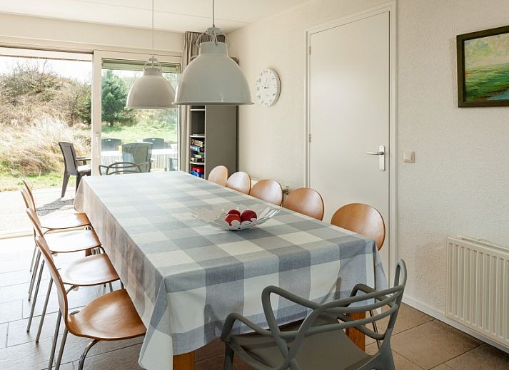 Zonnig terras van Villa Rietberg op Schiermonnikoog, vakantiehuis met buitenzitje en natuur.
