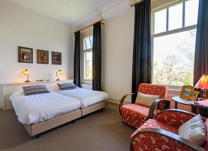 Lichte slaapkamer in B&B De Postoari Terschelling, Hoorn, met comfortabele bedden en kunst aan de muur.