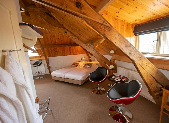 Lichte slaapkamer in B&B De Postoari Terschelling, Hoorn, met comfortabele bedden en kunst aan de muur.