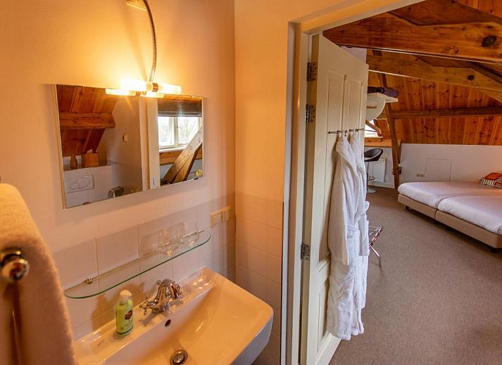 Lichte slaapkamer in B&B De Postoari Terschelling, Hoorn, met comfortabele bedden en kunst aan de muur.