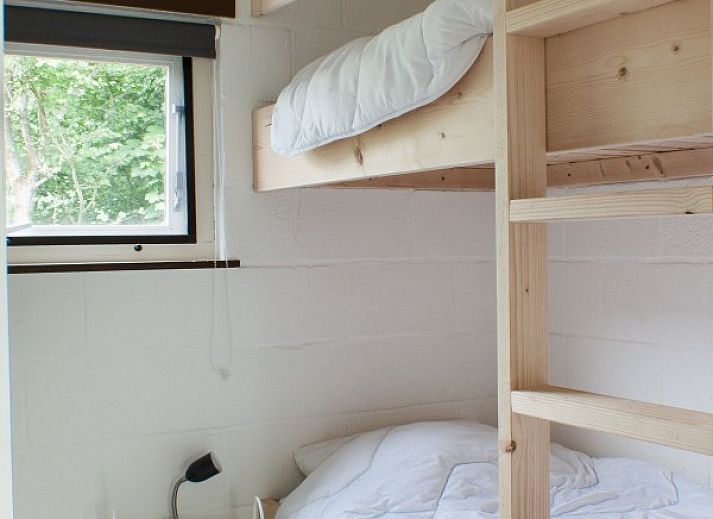 Ontspan op de ruime veranda van De Botter, een strandhuis in Makkum, met uitzicht op de groene omgeving.