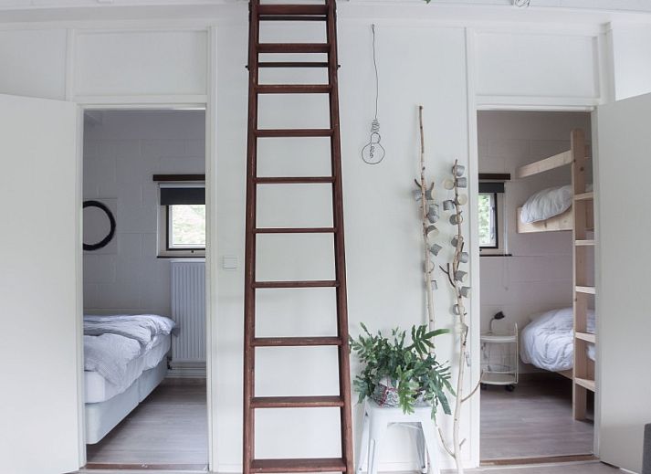 Ontspan op de ruime veranda van De Botter, een strandhuis in Makkum, met uitzicht op de groene omgeving.