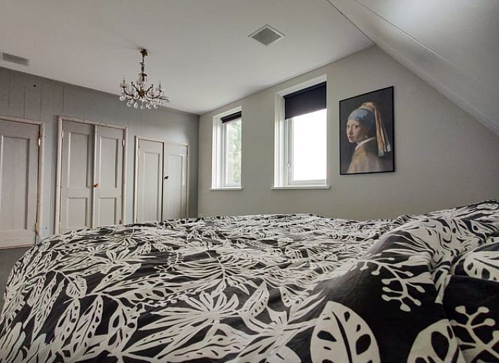 Ruime woonkamer in Vakantiehuisje in Molkwerum met moderne inrichting en uitzicht op de tuin.