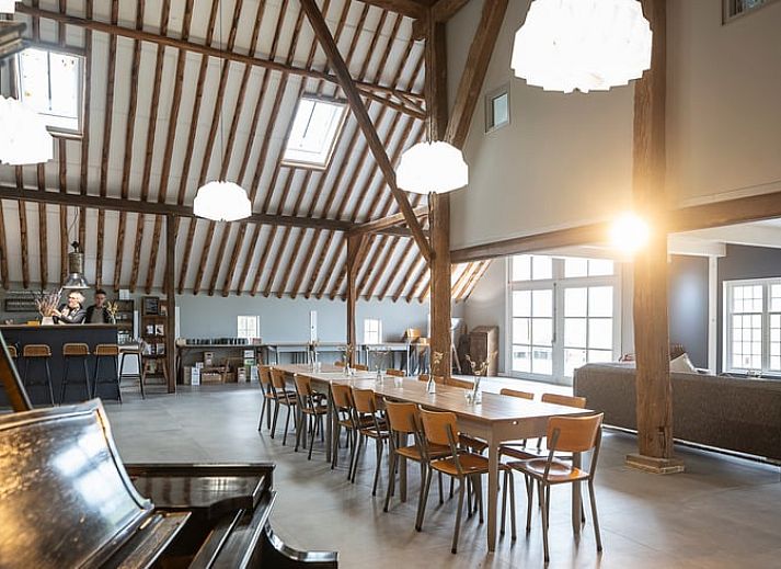 Buitenkant van Vakantiehuisje in Piaam omgeven door groene natuur en bomen, ideaal voor een ontspannen verblijf aan de Friese meren.