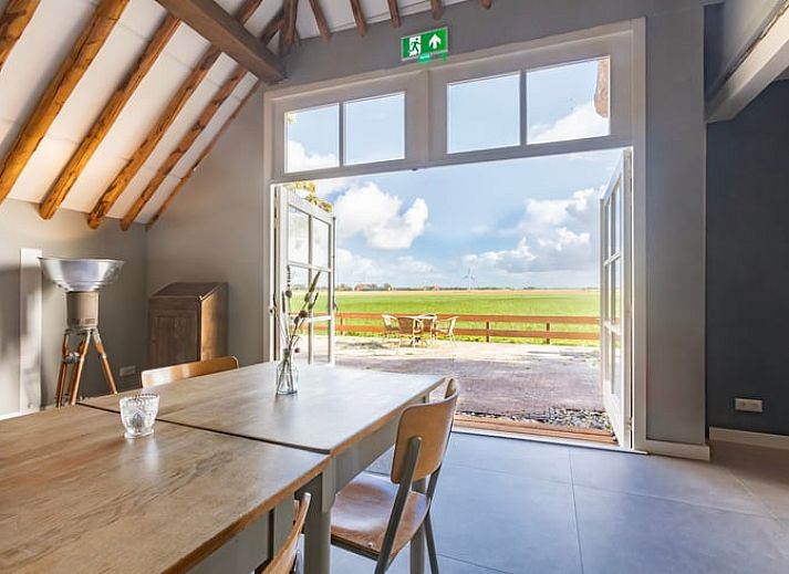 Buitenkant van Vakantiehuisje in Piaam omgeven door groene natuur en bomen, ideaal voor een ontspannen verblijf aan de Friese meren.