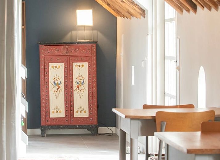 Grote eetzaal in Vakantiehuisje in Piaam met lange houten tafels, perfect voor groepsdiners aan de Friese meren.