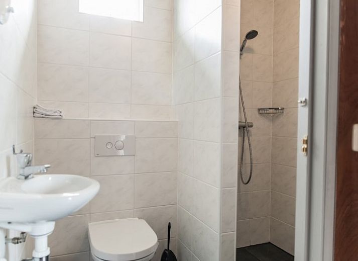 Gezellige binnenruimte van de lodge in Warns met houtkachel en eetruimte, nabij het IJsselmeer en de Friese meren.