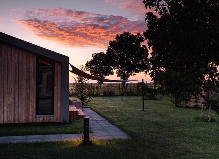 Aussenkamin mit brennendem Holz im Ferienhaus in Koudum, ideal fuer gemuetliche Abende.