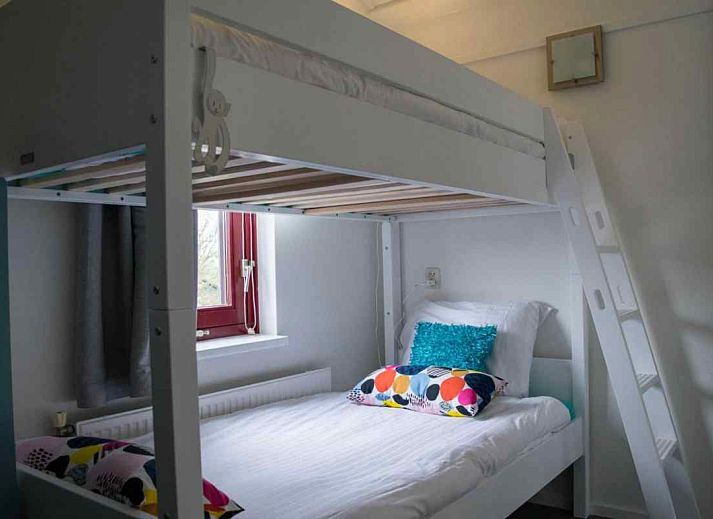 Luchtfoto van vakantiehuis FR061 in Koudum, gelegen aan de Friese meren, met rood dak en groene omgeving.