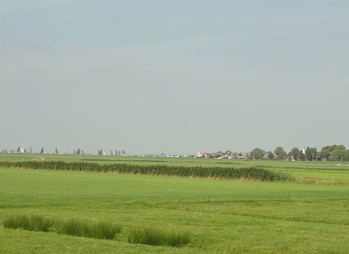 Huisje in Elahuizen, pittoresk vakantiehuis in de Friese meren, omgeven door groen.