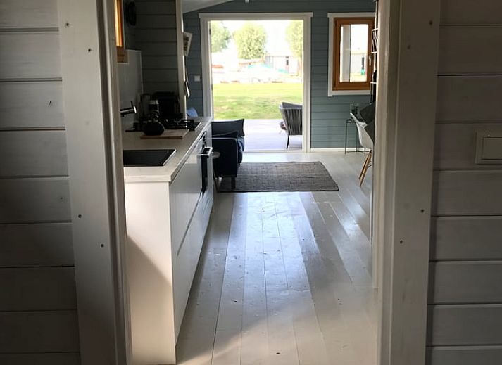 Houten veranda bij Vakantiehuis in Elahuizen met zitgelegenheid en uitzicht op de haven.