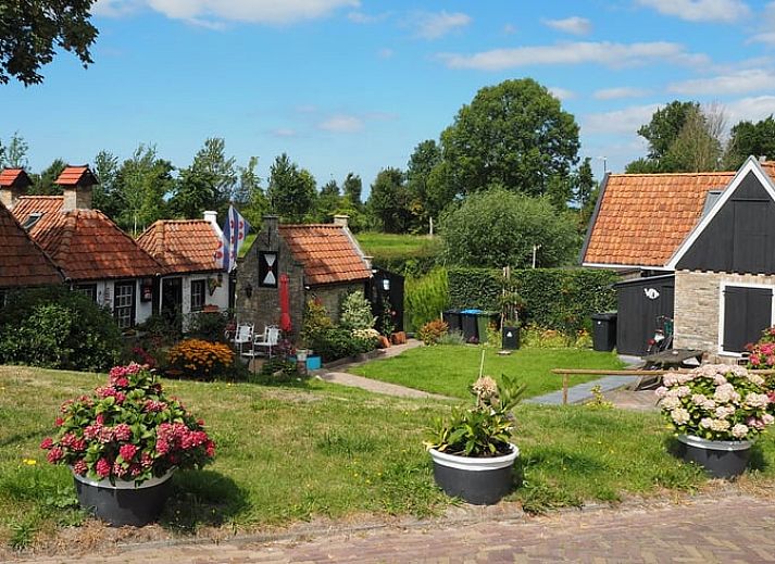 Gezellige eetruimte in Vakantiehuisje in It Heidenskip, gelegen aan de Friese meren, met houten tafel en comfortabele stoelen.