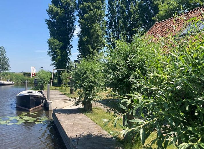 Gezellig vakantiehuis in Gaastmeer, gelegen aan de Fluessen met directe toegang tot het water en omringd door groene bomen.