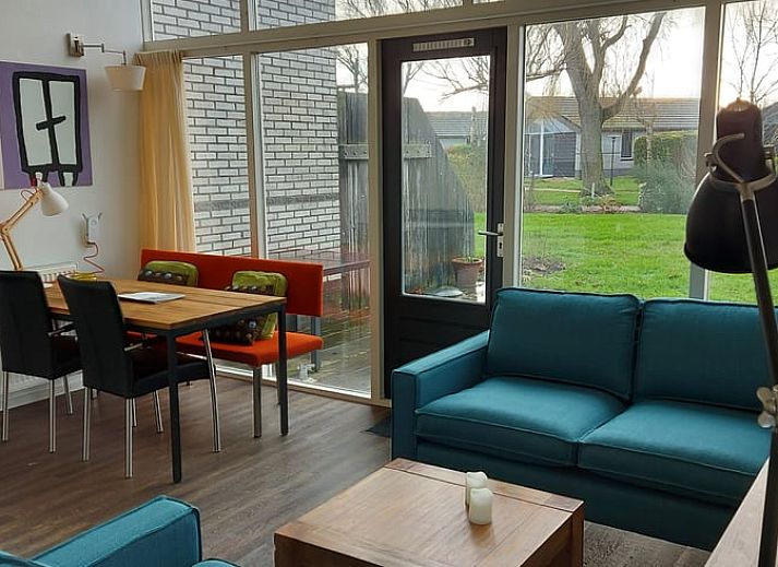 Gemuetliches Wohnzimmer im Ferienhaus in Gaastmeer mit Blick auf den gruenen Garten, ideal fuer Entspannung an den friesischen Seen.