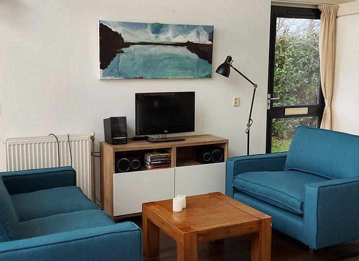 Gemuetliches Wohnzimmer im Ferienhaus in Gaastmeer mit Blick auf den gruenen Garten, ideal fuer Entspannung an den friesischen Seen.