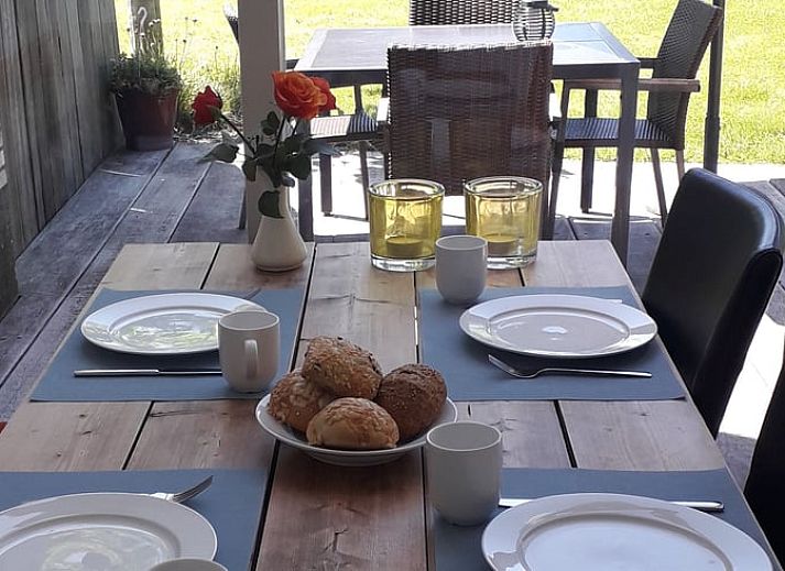 Gemuetliches Wohnzimmer des Ferienhauses in Gaastmeer, mit Blick auf den gruenen Garten in den Friesischen Seen, ideal zum Entspannen.
