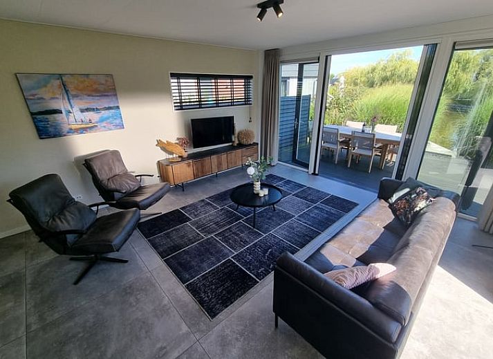 Modernes Ferienhaus in Balk, umgeben von viel Gruen und blauem Himmel, ideal fuer einen erholsamen Aufenthalt am Slotermeer.