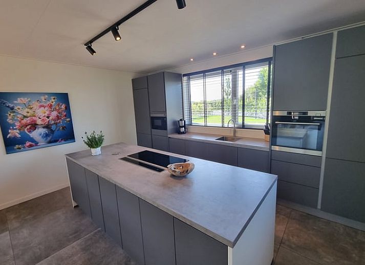 Helles Wohnzimmer im Ferienhaus in Balk mit Blick auf den Garten, ideal zum Entspannen an den friesischen Seen.