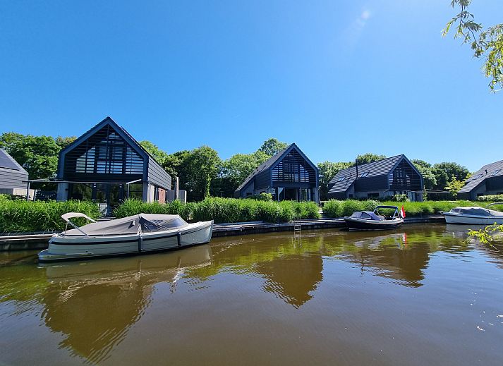 Stijlvolle woonkamer van vakantiehuis FR173 in Balk, met uitzicht op het terras en de groene omgeving.