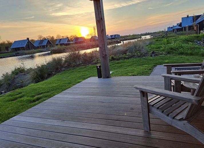 Ruime veranda van Huisje in Sint Nicolaasga met comfortabele zitruimte, ideaal voor ontspanning.